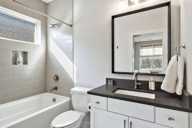 full bathroom with vanity, tiled shower / bath, and toilet