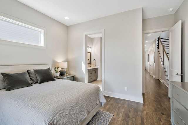 bedroom featuring ensuite bath and dark wood-type flooring