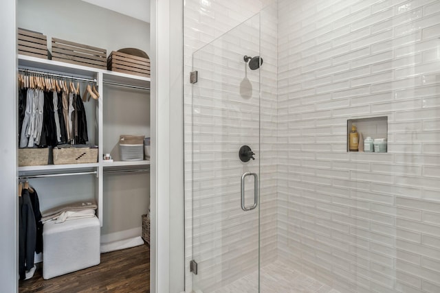 bathroom featuring hardwood / wood-style flooring and walk in shower