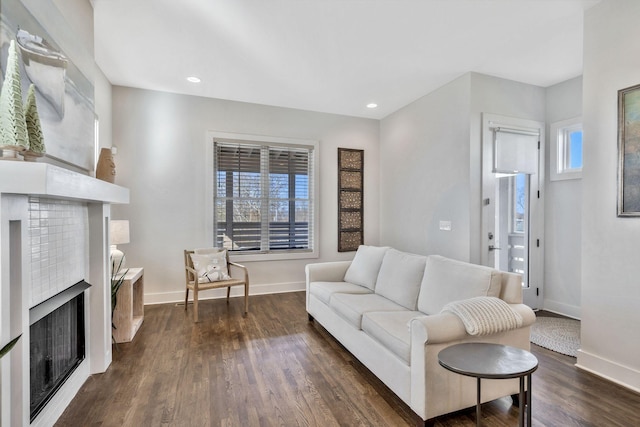 living room with dark hardwood / wood-style flooring and a brick fireplace