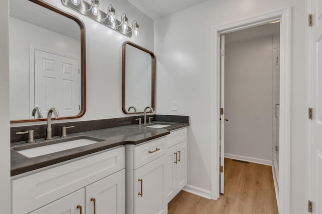 bathroom featuring a shower with door, wood-type flooring, and vanity