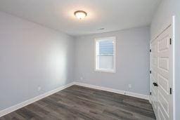 spare room with dark wood-type flooring