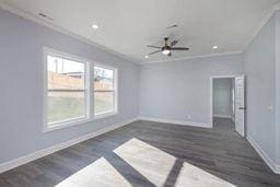 empty room featuring dark hardwood / wood-style flooring and ornamental molding