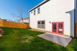 rear view of property featuring a yard and a patio area