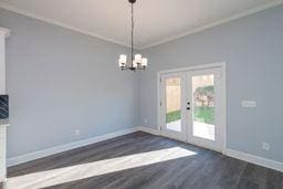 unfurnished dining area featuring crown molding, dark hardwood / wood-style floors, and french doors