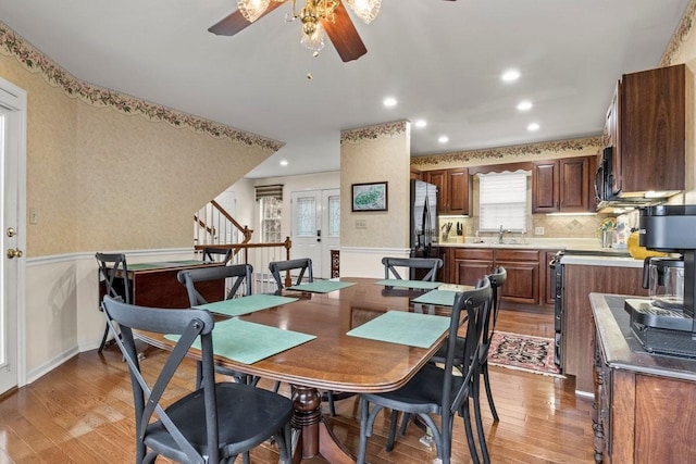 dining space featuring sink, ceiling fan, and light wood-type flooring