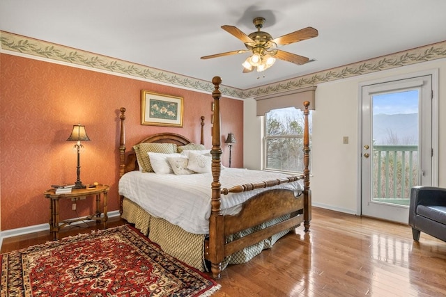 bedroom with access to exterior, hardwood / wood-style flooring, and ceiling fan