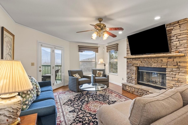 living room with hardwood / wood-style floors, a fireplace, and ceiling fan