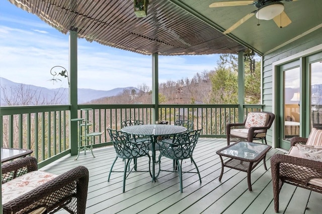 wooden terrace featuring ceiling fan and a mountain view