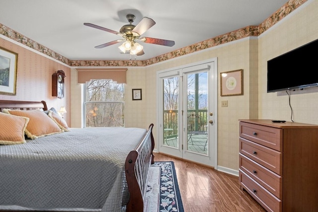 bedroom with ceiling fan, access to exterior, and hardwood / wood-style floors