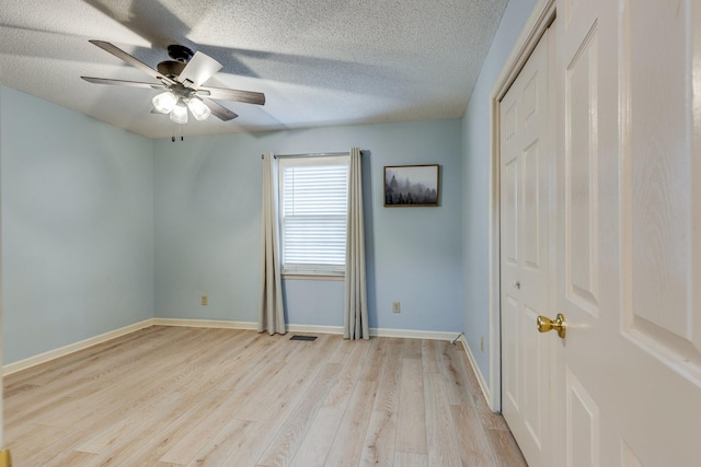 unfurnished bedroom with a closet, ceiling fan, a textured ceiling, and light hardwood / wood-style flooring