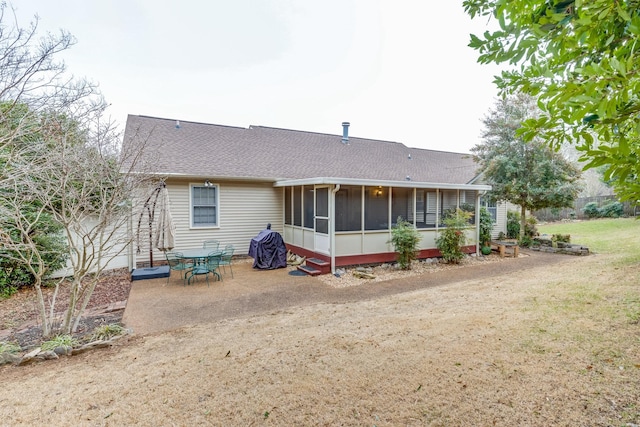 back of house featuring a yard, a patio area, and a sunroom