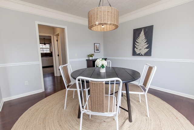 dining room with an inviting chandelier, crown molding, and dark wood-type flooring