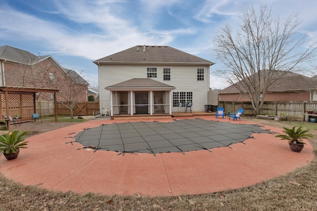 rear view of house featuring a patio, a sunroom, and a swimming pool side deck