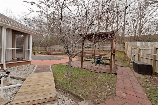 view of yard with a wooden deck, a sunroom, and a patio