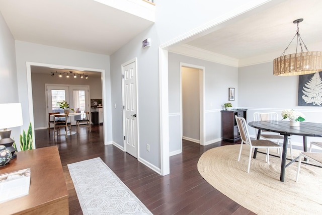 dining area with crown molding and dark wood-type flooring