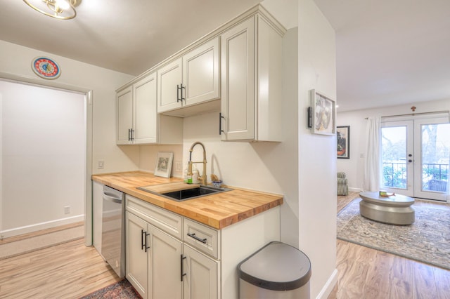 kitchen with french doors, sink, wooden counters, light hardwood / wood-style flooring, and dishwasher