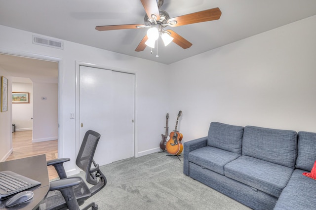 carpeted home office with ceiling fan