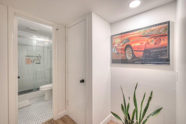 bathroom with tiled shower and toilet