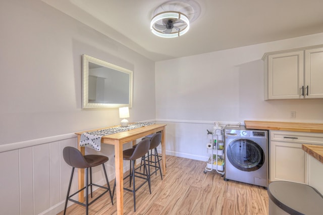 clothes washing area with washer / clothes dryer and light hardwood / wood-style floors