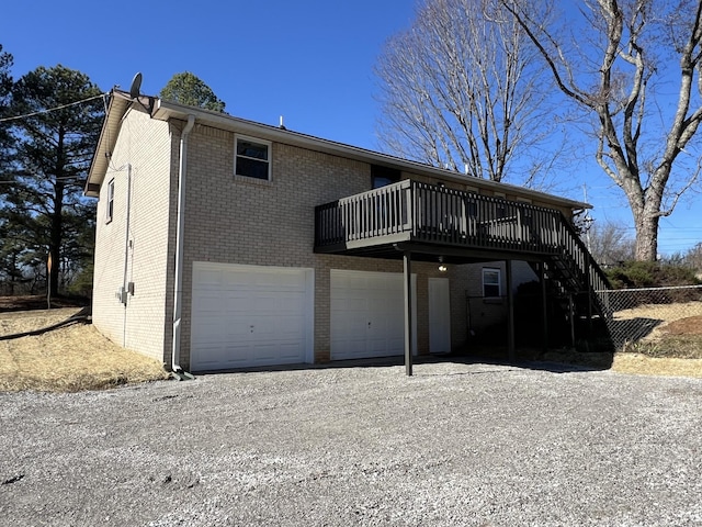 back of house with a garage and a deck