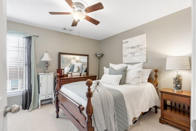 carpeted bedroom with multiple windows and ceiling fan