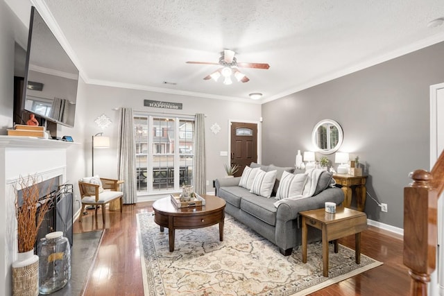 living room featuring hardwood / wood-style floors, ornamental molding, a textured ceiling, and ceiling fan