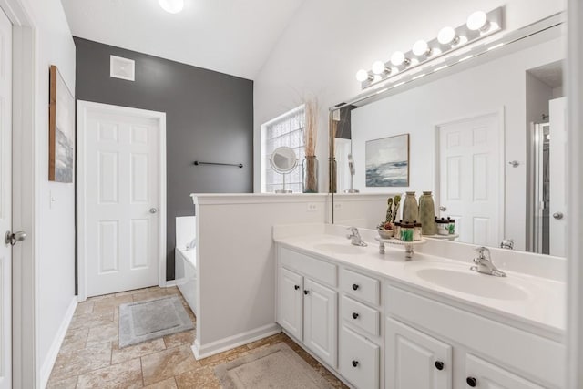 bathroom featuring vaulted ceiling, vanity, and a bathtub