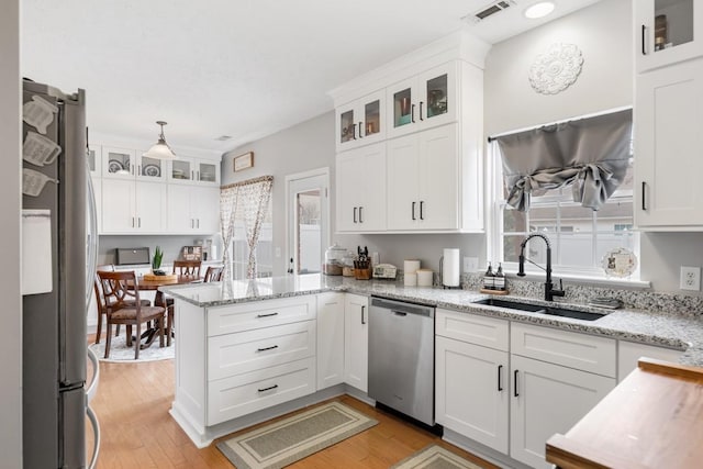 kitchen with sink, appliances with stainless steel finishes, light stone countertops, light hardwood / wood-style floors, and white cabinets