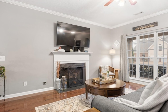 living room featuring hardwood / wood-style flooring, ceiling fan, and ornamental molding