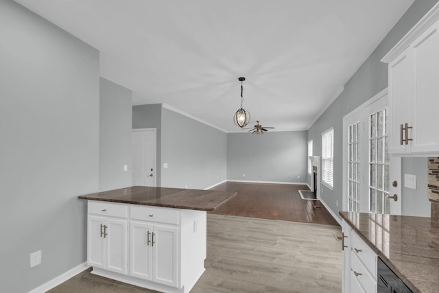 kitchen featuring white cabinets, light wood-type flooring, and kitchen peninsula