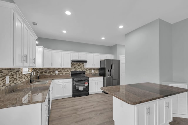 kitchen featuring black range oven, white cabinetry, sink, a center island, and stainless steel fridge with ice dispenser