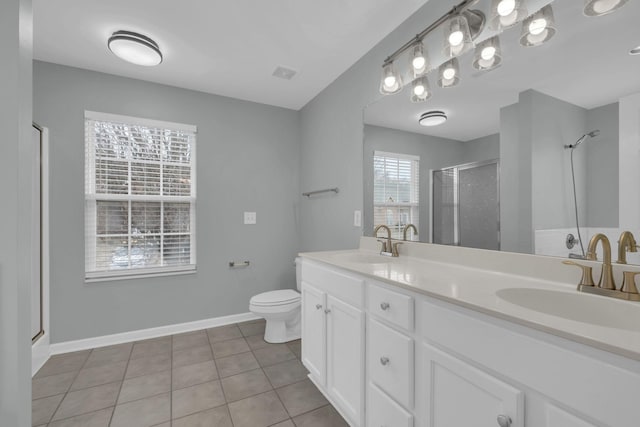 bathroom featuring tile patterned flooring, vanity, a shower with door, and toilet