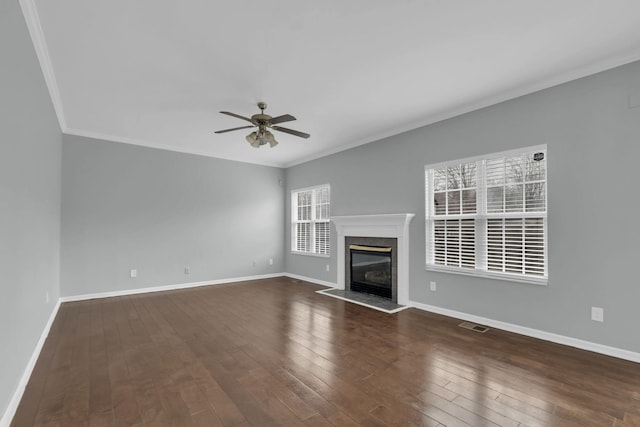 unfurnished living room featuring crown molding, dark wood-type flooring, a high end fireplace, and ceiling fan