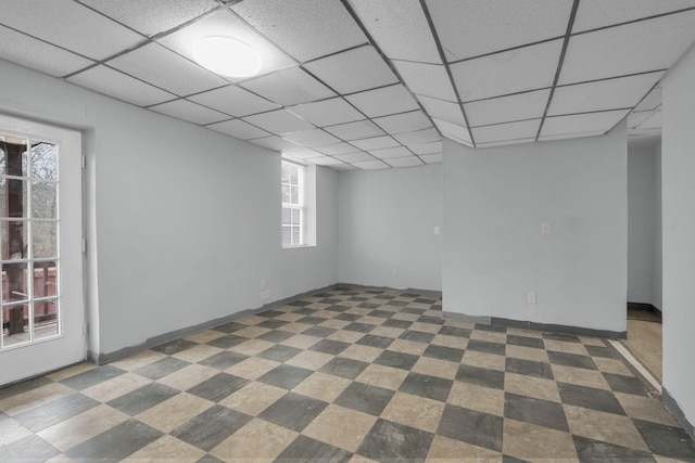 basement featuring a paneled ceiling and plenty of natural light