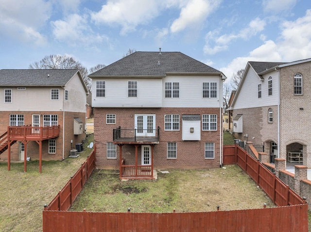 back of property with a wooden deck, a lawn, and central air condition unit