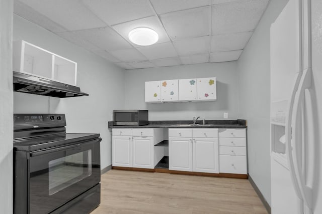 kitchen featuring white refrigerator with ice dispenser, black electric range oven, a drop ceiling, and white cabinets