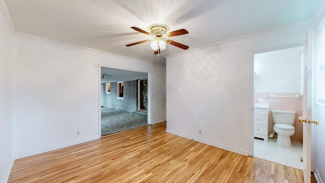 spare room featuring light hardwood / wood-style flooring, ornamental molding, and ceiling fan