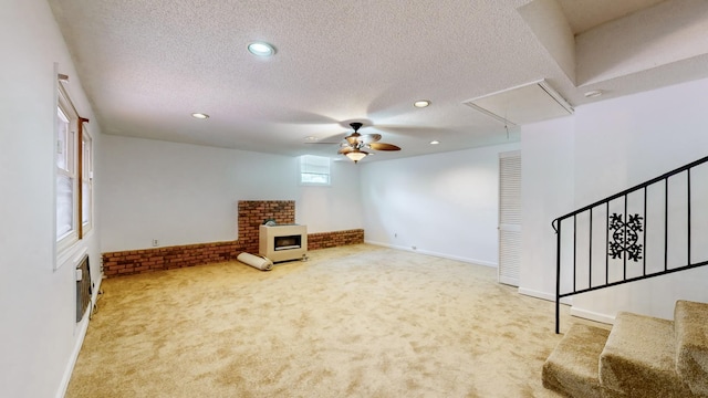 carpeted living room with ceiling fan and a textured ceiling