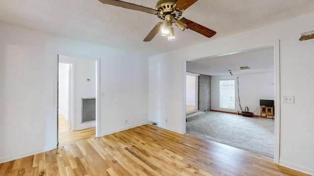 unfurnished room featuring light hardwood / wood-style floors and a textured ceiling