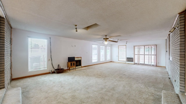 unfurnished living room with a textured ceiling, light colored carpet, an AC wall unit, and ceiling fan