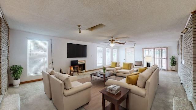 carpeted living room featuring ceiling fan and a textured ceiling