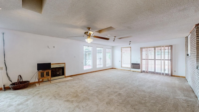 unfurnished living room featuring plenty of natural light, a wall unit AC, ceiling fan, and carpet flooring