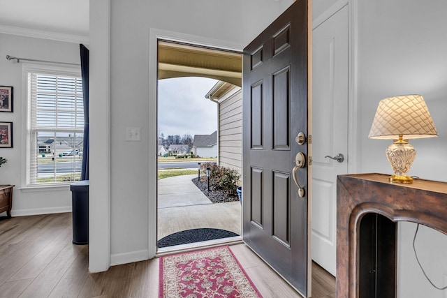 entryway with crown molding and light hardwood / wood-style flooring