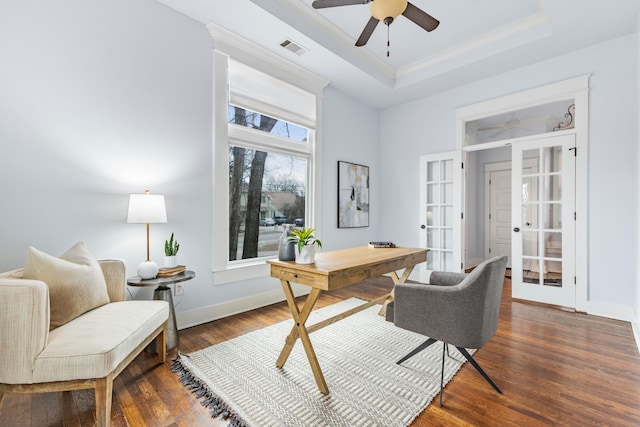 home office with a tray ceiling, dark wood-type flooring, ceiling fan, and french doors