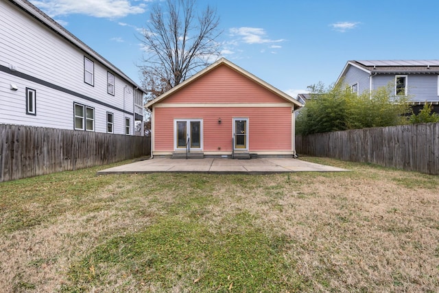 rear view of property with a yard and a patio area