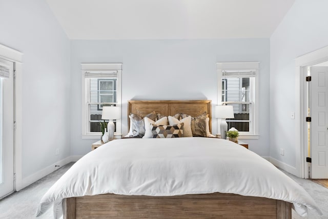 bedroom with lofted ceiling and light colored carpet