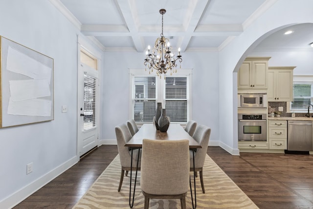 dining area with crown molding, dark hardwood / wood-style floors, coffered ceiling, a notable chandelier, and beamed ceiling