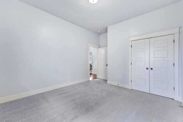 unfurnished bedroom featuring light colored carpet and a closet