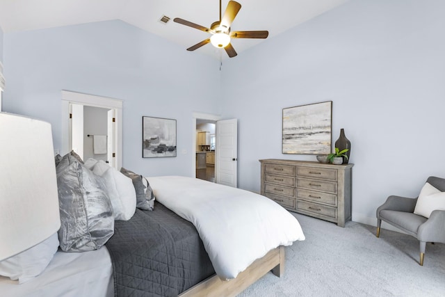 carpeted bedroom featuring ceiling fan, high vaulted ceiling, and ensuite bath